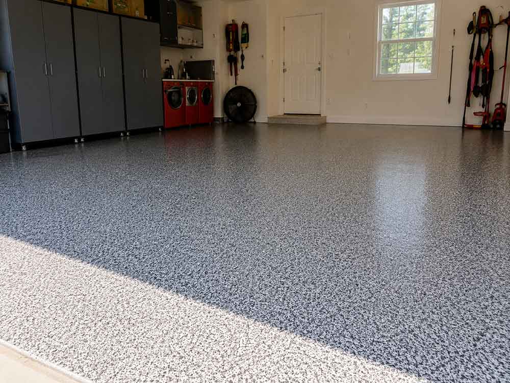 Blue steel flake epoxy garage floor with gray storage cabinets